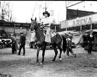 [Unidentified cowboy in wide chaps on tall horse]