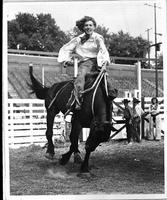 [Unidentified cowgirl riding bronc]