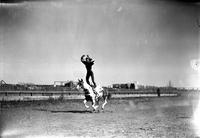 [Unidentified Cowgirl doing Hippodrome Stand with arms raised above head forming a circle]