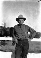 [Elderly man with name tag/badge showing his name "Chas. E. Martin or Robbin" and "Rodeo Manager"]