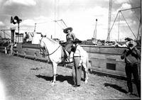 [Unidentified cowboy and possibly Sally Rand by announcer's platform]