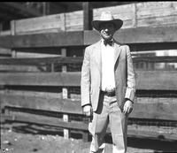 [Possibly Fred Beeson in formal western-attire standing in front of fence]