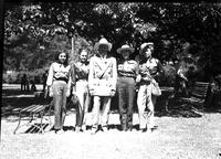 [Gene Autry with four unidentified women in western attire standing in park]