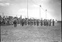 [Cowboy marching band performing in front of spectators]