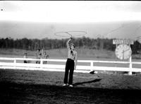 [Unidentified Standing cowgirl spinning rope loop above her head with timer clock behind]