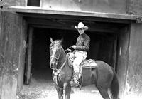 [Col. Jim Eskew on horse in front of barn entrance]