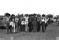 [Group of nine cowgirls and two little girls posed]