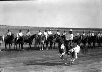 [Unidentified cowboy on Pinto galloping in front of a group of mounted cowboys]