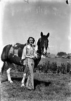 [Possibly Ruth Mariam standing beside horse]