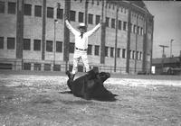 [Unidentified cowboy standing on back legs of horse lying on its back]