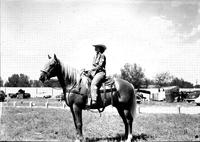 [Unidentified cowgirl contestant with "Colo. State…sash" atop horse]