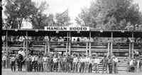 [Line of rodeo contestants in front of chutes at Mandan Rodeo]