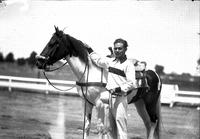 [Unidentified male trick rider posed by horse]