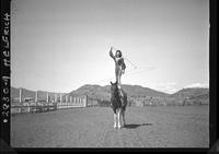 [Nancy Kelley standing atop horse spinning rope]
