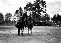 [Unidentified Man in suit & possibly Ruth Mix on horseback, Cowgirl with high-crowned hat and chaps]