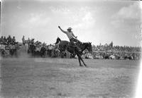 [Louis Brooks staying with Saddle Bronc "Bad Whiskey" with right arm extended up and behind him]