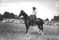 [Unidentified older cowboy in plain work-clothes on horse]
