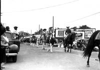 [Possibly Floyd Gale, Vivian White, and Alice Adams lead line of cowboys & cowgirls]