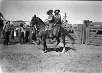 [Possibly Sally Rand sitting on saddle in front of unidentified cowboy with "Cremer" chaps]