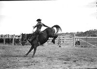 [Unidentified Cowboy riding and staying with rear leg kicking bronc]