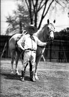 [Possibly Cy Compton in light shirt and pants holding horse]