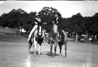 [Possibly Florence Randolph wearing short Rose-decorated vest on horseback shaking hands with man]