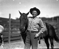 [Possibly Gene Ross smoking and standing beside horse]