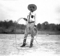 [Unidentified cowboy standing and holding rope]