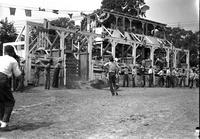 [Unidentified Rider and Saddle Bronc down in front of chute #2; cowboy runs to assist]