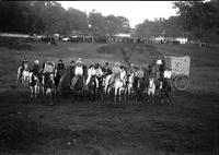 [Group of mounted cowboys and cowgirls in a field at the Flying X Ranch Rodeo]