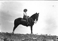 [Unidentified cowgirl atop horse]