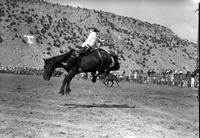 [Unidentified Cowboy riding twisting airborne bareback bronc]