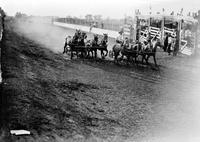 [Chariot racing as two four-horse teams vie for the lead on track]