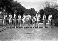 [Mamie Francis & California Frank on horses amid five mounted cowgirls and three mounted cowboys]