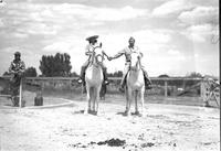 [Possibly Sally Rand & Turk Greenough in military attire on horses]