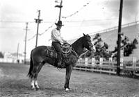 [Unidentified Cowboy in striped shirt on roping horse in arena]