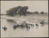 [Cowboys and Cowgirls on horseback and in a buggy crossing a river]