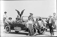 [Leonard Stroud, cowboys, and cowgirls in and around an automobile, portrait photo]