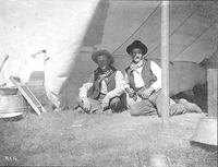 Two cowboys sitting in a tent