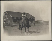 [Man on horseback in front of a barn]