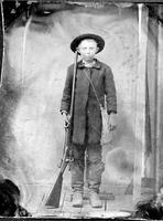 Boy wearing boots and holding a percussion rifle