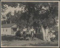 [2 cowgirls and a man on horseback looking at a man and woman sitting in a hammock]