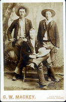 Three cowboys with hats posed in studio