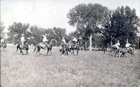 Unidentified saddle bronc rider amidst pickup men