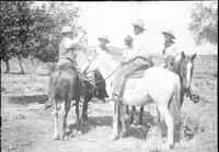 Group of cowboys on chatting on horseback