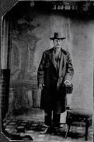 Dapper Gentleman wearing long coat, cowboy hat & boots