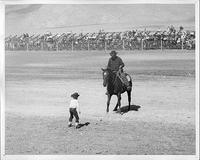 Bob Crosby on horse in front of small boy