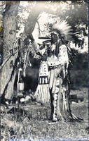 Unidentified Native American man standing near animal intestines