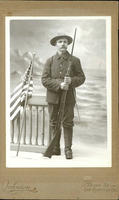 Soldier with rifle and bayonet posing with American flag