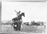 Leonard Stroud riding "Black Diamond" over human hurdle jump, Colorado State Fair, 1927